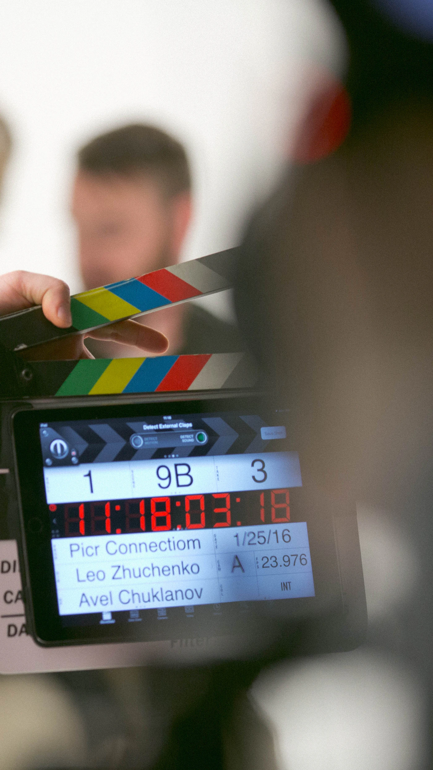 Hand holding a clapperboard on set before a take