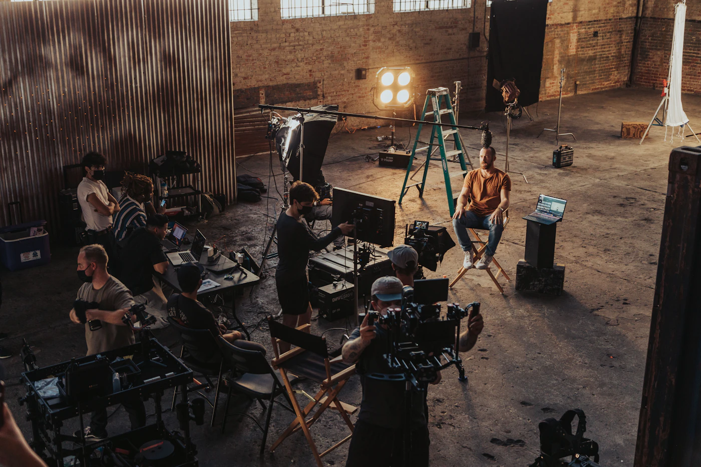 Crew gathered around camera and lighting gear in a warehouse studio