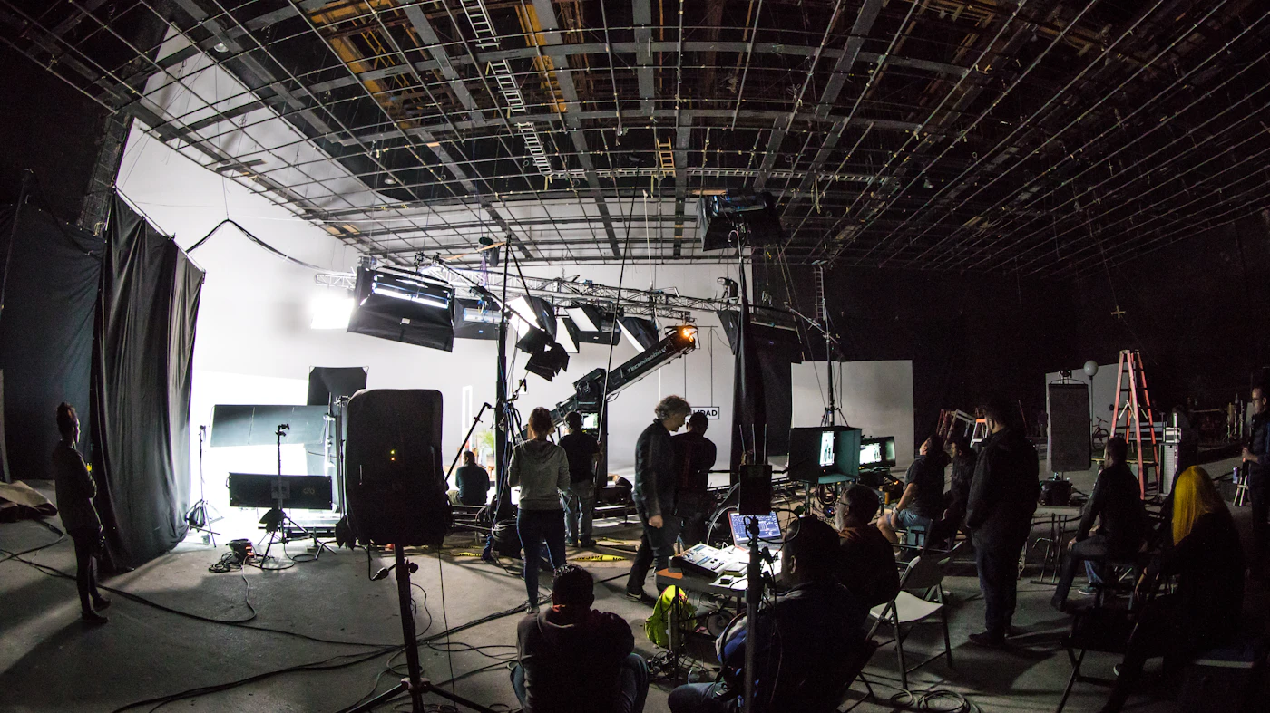 Film crew working on a soundstage under studio lights
